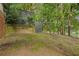 Landscaped backyard features grass, a black chainlink fence, and mature trees at 195 Arizona Ne Ave # 197, Atlanta, GA 30307