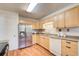 Bright kitchen featuring stainless steel refrigerator, wood cabinets, and granite countertops at 202 Garden Ct, Atlanta, GA 30328