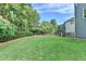 Side view of a backyard with grass, trees, and fence at 306 Mill Rdg, Canton, GA 30114