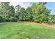Large backyard with grass and trees, privacy fence in the background at 306 Mill Rdg, Canton, GA 30114