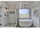 Glass enclosed shower and freestanding tub illuminated by modern light fixture in this bathroom at 306 Mill Rdg, Canton, GA 30114