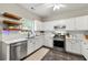 Well-lit kitchen featuring white cabinetry, stainless steel appliances, and open wooden shelving at 1612 Silver Oak Dr, Austell, GA 30106