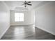 Spacious bedroom with tray ceiling, fan, natural light, and modern gray flooring for a serene living space at 2682 Field Spring Dr, Lithonia, GA 30058