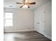 This bedroom features wood flooring, white walls, a ceiling fan, a closet, and a window at 2682 Field Spring Dr, Lithonia, GA 30058