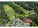 Aerial view of a golf course with lush greens, mature trees, and a nearby clubhouse at 3525 Stone Cliff Way, Woodstock, GA 30189