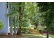 Backyard view featuring mature trees, natural fence, and the home's exterior at 3525 Stone Cliff Way, Woodstock, GA 30189