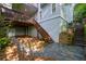 Backyard area featuring a stone patio, wooden stairs, and access to a lower level at 3525 Stone Cliff Way, Woodstock, GA 30189