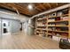 Open basement area with laminate floors, open rafter ceiling, storage shelving, and an adjacent bathroom at 3525 Stone Cliff Way, Woodstock, GA 30189