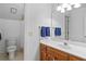 Bright bathroom featuring a single sink vanity with wood cabinets and a large mirror at 3525 Stone Cliff Way, Woodstock, GA 30189