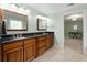 Bathroom showcasing dual sinks with dark wood cabinets and travertine tile floor at 3525 Stone Cliff Way, Woodstock, GA 30189