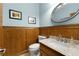 Charming powder room featuring wood paneling, granite countertop, and classic fixtures at 3525 Stone Cliff Way, Woodstock, GA 30189