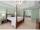 Bright and airy bedroom boasts a four-poster bed and sitting area with large windows at 3525 Stone Cliff Way, Woodstock, GA 30189