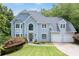 Stately two-story home with a manicured lawn, arched windows, and a two-car garage at 3525 Stone Cliff Way, Woodstock, GA 30189