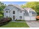 Beautiful two-story home featuring a manicured lawn and a two-car garage at 3525 Stone Cliff Way, Woodstock, GA 30189