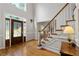 Bright foyer with hardwood floors, a decorative front door with sidelights, and a staircase with white risers at 3525 Stone Cliff Way, Woodstock, GA 30189