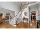 Traditional foyer featuring hardwood floors, staircase with carpet runner, and entry to the living room and kitchen at 3525 Stone Cliff Way, Woodstock, GA 30189