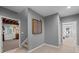 Hallway featuring grey paint, carpet, golf ball display, and access to basement workshop at 3525 Stone Cliff Way, Woodstock, GA 30189