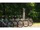 Community bike share stand and station showcasing many bicycles in a green wooded park at 4231 Millcroft Pl # 207, Buford, GA 30518