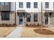 A view of the townhome entrance with a blue door and manicured front yard at 4231 Millcroft Pl # 207, Buford, GA 30518