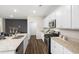Modern kitchen featuring stainless steel appliances, granite countertops, white cabinets, and wood flooring at 1240 Arnhem Dr, Hampton, GA 30228