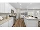 Bright kitchen with white cabinets, granite countertops, stainless steel appliances, and hardwood floors at 1240 Arnhem Dr, Hampton, GA 30228