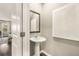 Stylish powder room with a pedestal sink, decorative mirror, and modern artwork at 1240 Arnhem Dr, Hampton, GA 30228