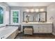 Elegant bathroom features a soaking tub, marble counters, and bright window at 2196 Kildare Nw Way, Kennesaw, GA 30152