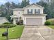 Charming two-story home with a well-manicured lawn, inviting entryway, and two-car garage at 265 Edinburgh Ln, Woodstock, GA 30188