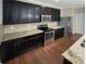 Modern kitchen featuring granite countertops, stainless steel appliances, and dark wood cabinets at 265 Edinburgh Ln, Woodstock, GA 30188