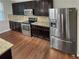 Well-equipped kitchen with stainless steel appliances, granite countertops, and dark wood cabinetry at 265 Edinburgh Ln, Woodstock, GA 30188