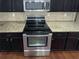Modern kitchen with a stainless steel range, microwave, and tan granite countertops at 265 Edinburgh Ln, Woodstock, GA 30188