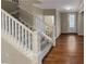 Carpeted staircase with white railing leading to the upper level, and hardwood flooring at 265 Edinburgh Ln, Woodstock, GA 30188