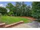 Expansive backyard featuring brick retaining wall, green lawn, and mature trees at 280 Blackland Nw Rd, Atlanta, GA 30342