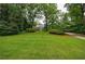 Expansive front lawn leading to a brick home nestled among mature trees and manicured hedges at 280 Blackland Nw Rd, Atlanta, GA 30342