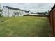 View of a spacious backyard, home exterior, well-kept lawn, and perimeter fence at 3378 English Elm Way, Loganville, GA 30052