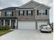 Beautiful two-story home featuring a brick and stone facade, and a two-car garage at 3378 English Elm Way, Loganville, GA 30052