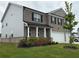 Two-story home with a brick front, black shutters, a covered porch, and a well-maintained lawn at 3378 English Elm Way, Loganville, GA 30052