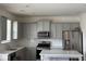 Modern kitchen with gray cabinetry, stainless steel appliances, and a white countertop island at 3378 English Elm Way, Loganville, GA 30052