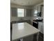 Kitchen with gray cabinets, stainless steel appliances, a kitchen island and a window at 3378 English Elm Way, Loganville, GA 30052