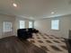 Bright living room features a large sectional sofa, plush patterned rug, and a door to the outside at 3378 English Elm Way, Loganville, GA 30052