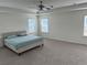 Spacious bedroom with a ceiling fan, tray ceiling, carpet floors and lots of natural light at 3378 English Elm Way, Loganville, GA 30052