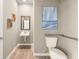 Neutral powder room featuring a wall hung sink, modern artwork, and grab bars at 1209 Arnhem Dr, Hampton, GA 30228