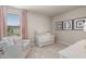 Charming Bedroom featuring a white crib, comfortable chair, and soft pink accents at 1209 Arnhem Dr, Hampton, GA 30228