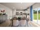 Open dining area with wood floors, natural light, view of kitchen and access to backyard through sliding glass doors at 1209 Arnhem Dr, Hampton, GA 30228