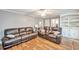 Spacious living area with sleek hardwood floors, a ceiling fan, and stylish brown leather seating at 2165 Shillings Chase Nw Dr, Kennesaw, GA 30152