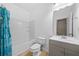 Bright bathroom features a tub with shower, tile flooring, and single sink vanity at 262 Bell Grove Ln, Suwanee, GA 30024
