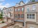 Brick townhome showcasing a private balcony, neutral paint, attached garage, and professional landscaping at 262 Bell Grove Ln, Suwanee, GA 30024