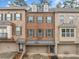 Brick townhome highlighting an attached garage, neutral paint, professional landscaping, and covered entry at 262 Bell Grove Ln, Suwanee, GA 30024