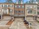 Brick townhome highlighting an attached garage, neutral paint, professional landscaping, and covered entry at 262 Bell Grove Ln, Suwanee, GA 30024