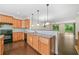 Kitchen features dark hardwood floors, wood cabinets, and an open view to the living area at 262 Bell Grove Ln, Suwanee, GA 30024